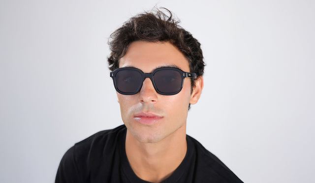 Man in a black tee wearing Bogota E Sunglasses in Black