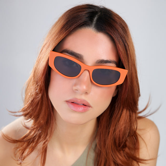Another angle of woma with red hair in an olive blouse wearing Alexa Sunglasses Aperol with Grey Flat