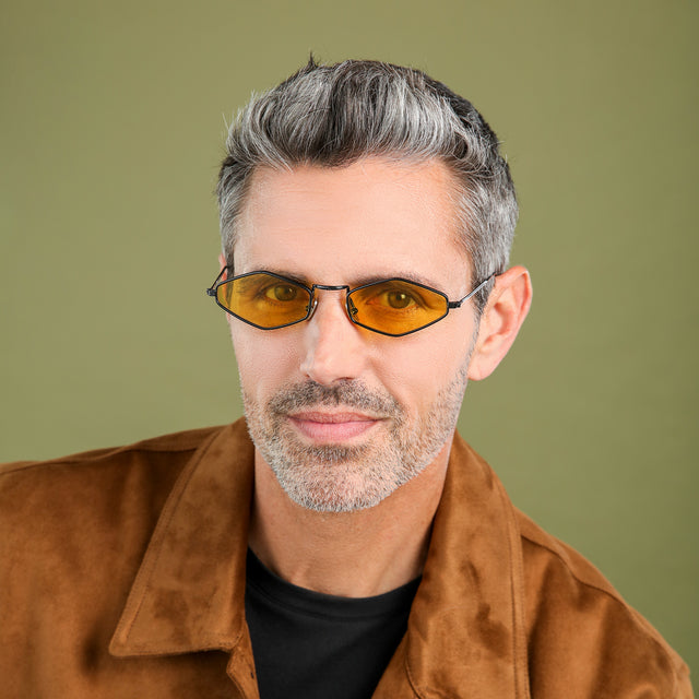 Model with salt and pepper hair and beard in a suede jacket wearing Astoria Sunglasses Black with Honey Flat See Through