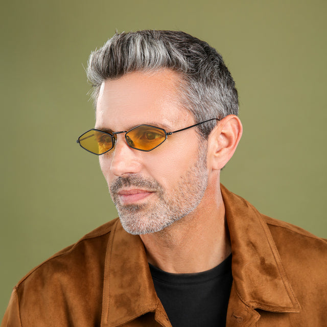 Model with salt and pepper hair and beard in a suede jacket looking right wearing Astoria Sunglasses Black with Honey Flat See Through