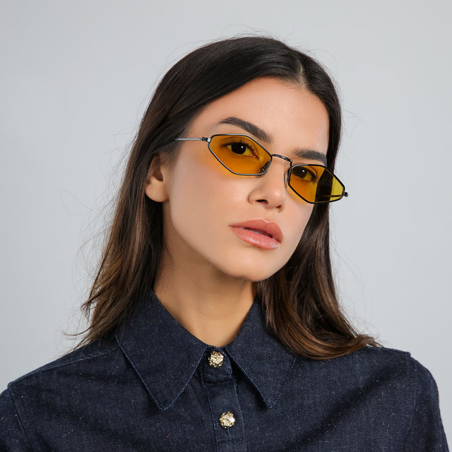 Woman with brown hair in a denim jacket wearing Astoria Sunglasses Black with Honey Flat See Through