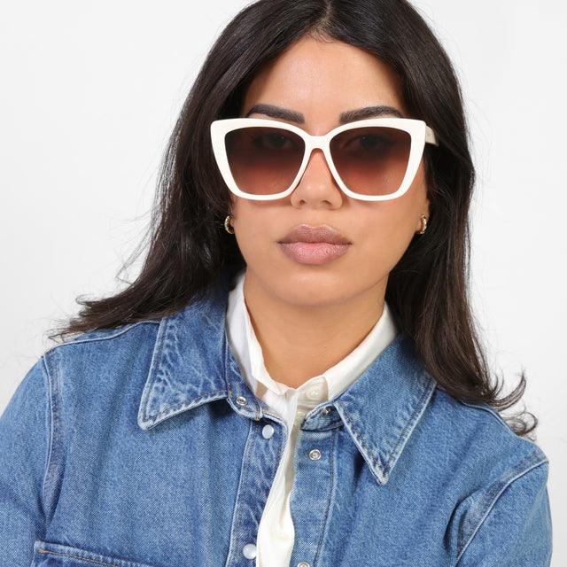 Brunette model in a denim jacket wearing Barcelona Sunglasses Cream with Brown Flat Gradient