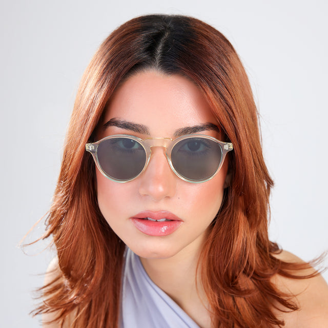 Woman with red hair in a periwinkle blouse wearing Capri Sunglasses Champagne with Olive