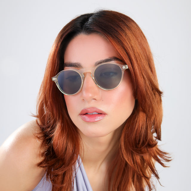 Another angle of woman with red hair in a periwinkle blouse wearing Capri Sunglasses Champagne with Olive