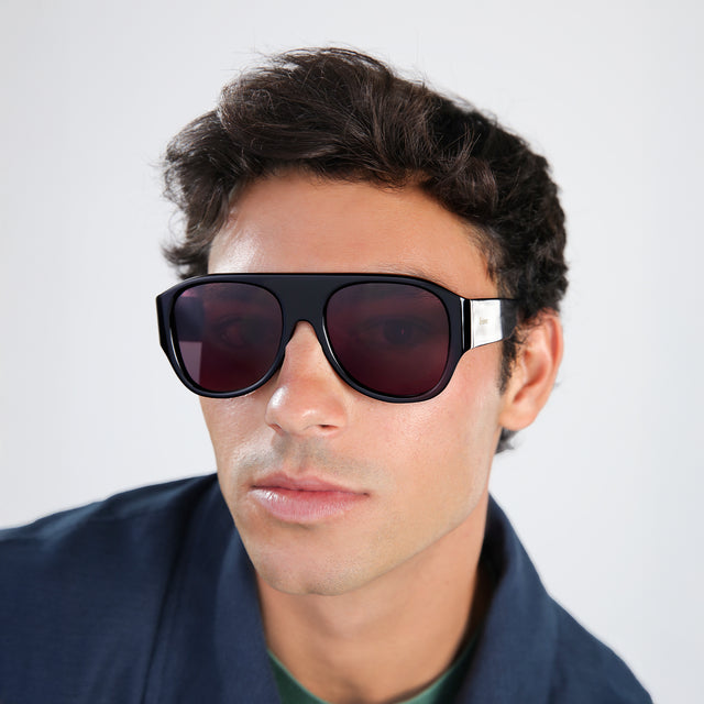 Man in a navy jacket wearing Colorado Sunglasses Black with Plum See Through