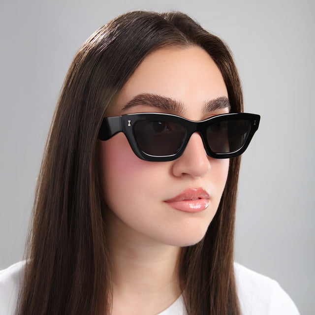 Another angle of brunette woman in a white tee wearing Donna Sunglasses Black with Grey