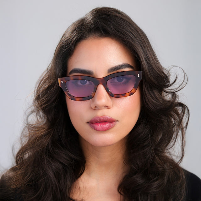 Another angle of woman with curled, brown hair wearing Donna Sunglasses Havana with Plum See Through