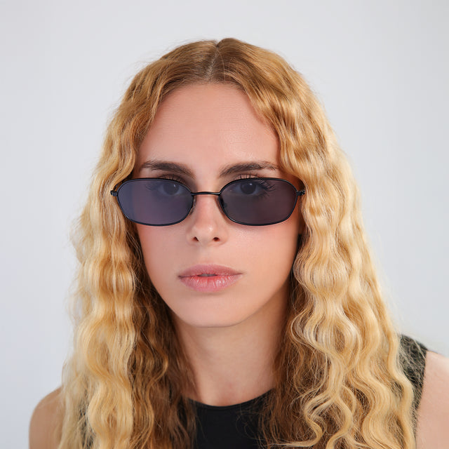 Woman with blonde, wavy hair wearing East Houston Sunglasses Matte Black with Grey Flat