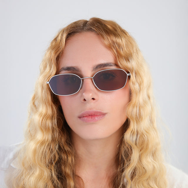 Woman with blonde, wavy hair wearing East Houston Sunglasses Silver with Brown Flat