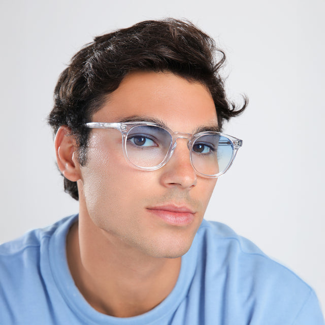Man in a blue shirt wearing Eldridge Sunglasses Clear with Blue Flat Gradient See Through