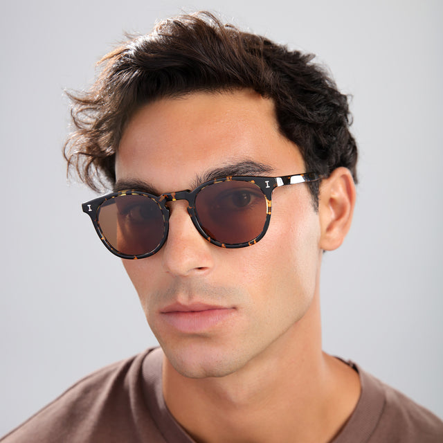 Man with brown hair in a brown shirt wearing Eldridge Sunglasses Flame with Brown Flat