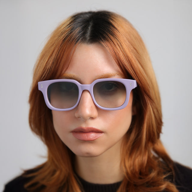Another angle of model with red hair wearing Ellison Sunglasses Matte Lavender with Olive Flat Gradient