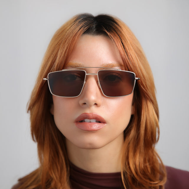 Another angle of model with red hair wearing Jane Sunglasses Rose Gold with Brown