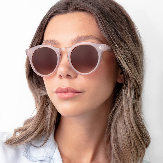 Brunette woman in a blue blouse wearing Leonard II E Sunglasses Thistle with Brown Gradient