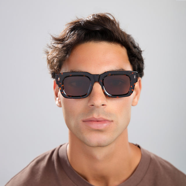 Man with brown hair in a brown shirt wearing Lewis 50 Sunglasses Flame with Brown Flat