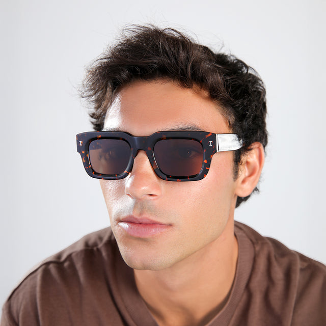 Another angle of man with brown hair in a brown shirt wearing Lewis 50 Sunglasses Flame with Brown Flat