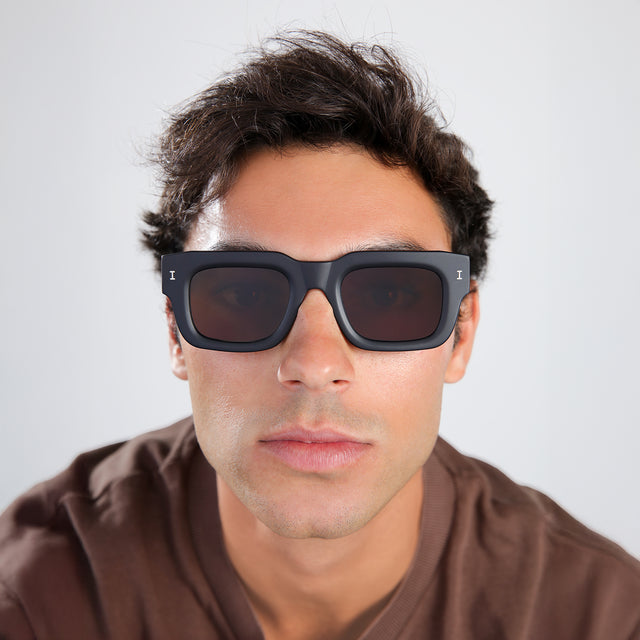 Another angle of man with brown hair in a brown shirt wearing Lewis 50 Sunglasses Matte Black with Brown Flat