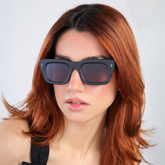 Another angle of woman with red hair in a black blouse Lewis 50 Sunglasses side view in Matte Black / Brown Flat