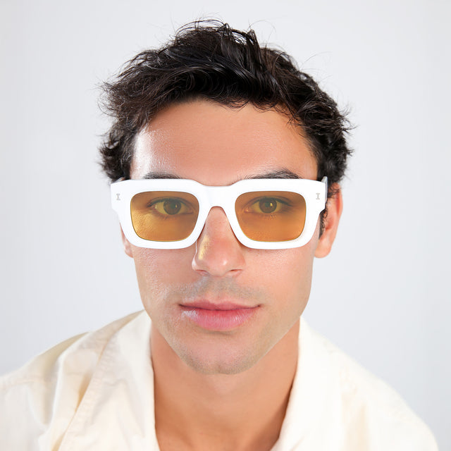 Man with brown hair in a pastel linen shirt wearing Lewis 50 Sunglasses White with Honey Flat See Through
