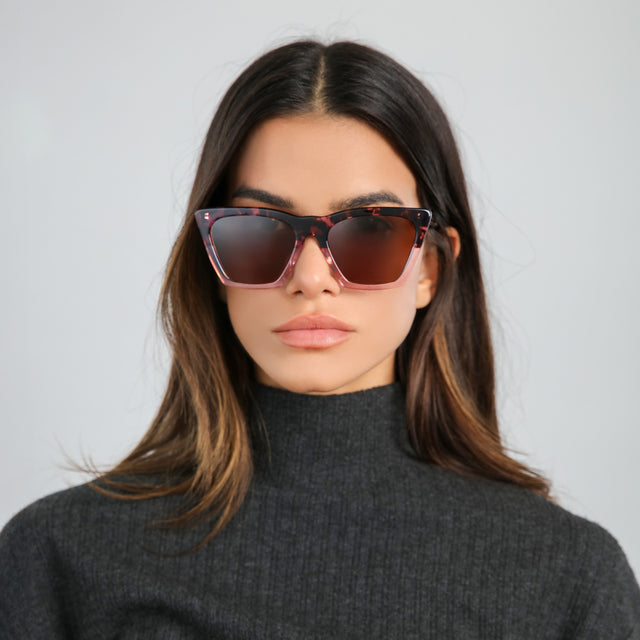 Brunette woman in a gray turtleneck wearing Lisbon Sunglasses Cherry Blossom with Brown