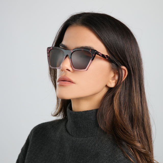Another angle of brunette woman in a gray turtleneck wearing Lisbon Sunglasses Cherry Blossom with Brown