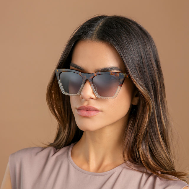 Another angle of brunette woman in a clay blouse wearing Lisbon Sunglasses H/H Maple Bone with Grey Gradient