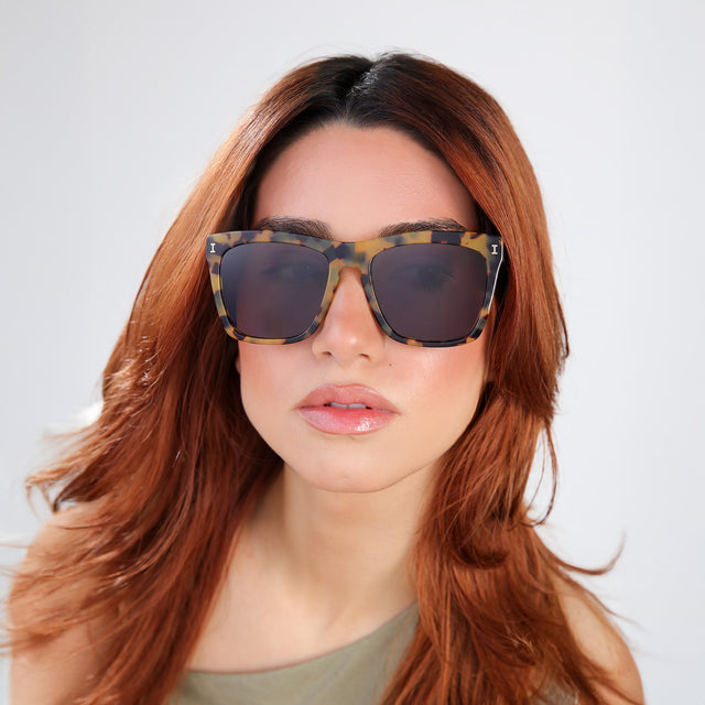 Woman with red hair in an olive blouse wearing Los Feliz Sunglasses Tortoise with Grey