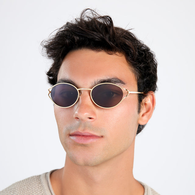 Another angle of man with brown hair in a beige waffled sweatshirt wearing Maria Sunglasses Gold with Brown