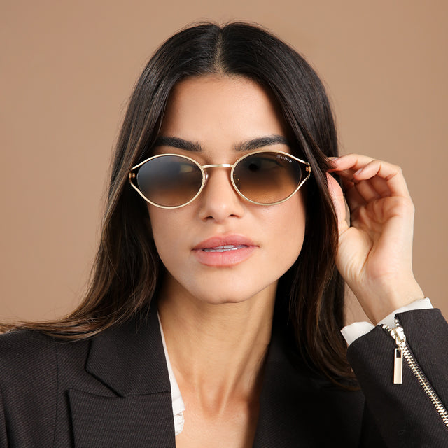 Brunette model in a black blazer wearing Maria Sunglasses Rose Gold with Taupe Gradient