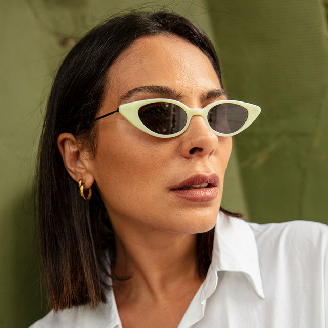 Woman with brown hair in a white blouse wearing Marianne Sunglasses Mint/Matte Black with Grey Flat