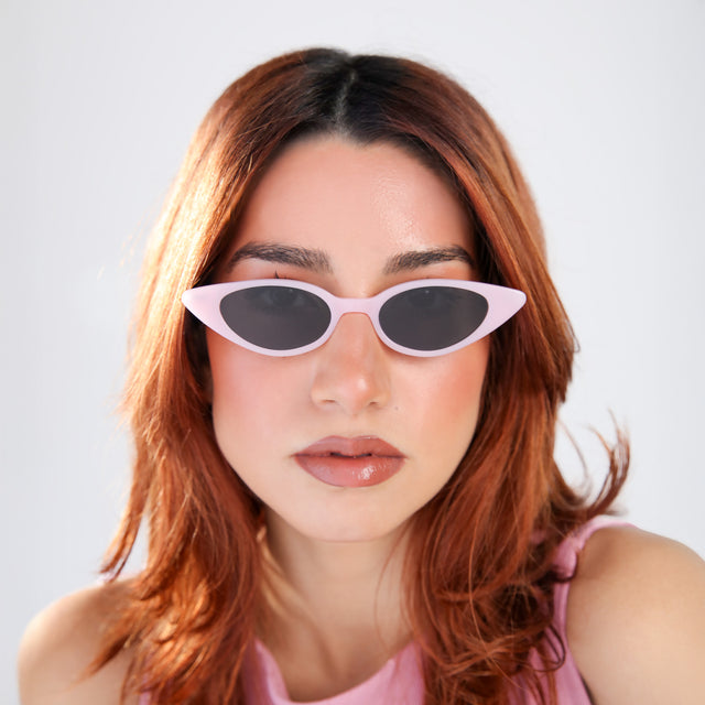 Woman with red hair in a pink blouse wearing Marianne Sunglasses Pale Pink/Gunmetal with Grey Flat