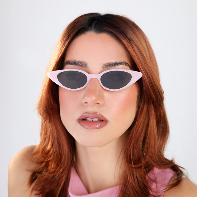 Another angle of woman with red hair in a pink blouse wearing Marianne Sunglasses Pale Pink/Gunmetal with Grey Flat