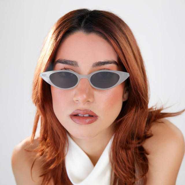 Another angle of woman with red hair in a white blouse wearing Marianne Sunglasses Powder/Gunmetal with Grey Flat