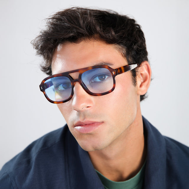 Man in a navy jacket wearing Memphis Sunglasses Havana with Blue Gradient See Through