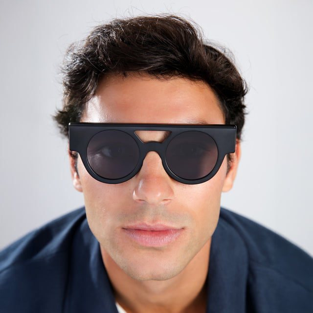 Man in a navy shirt wearing Meyer (15 Year Anniversary) Sunglasses Matte Black with Grey Flat