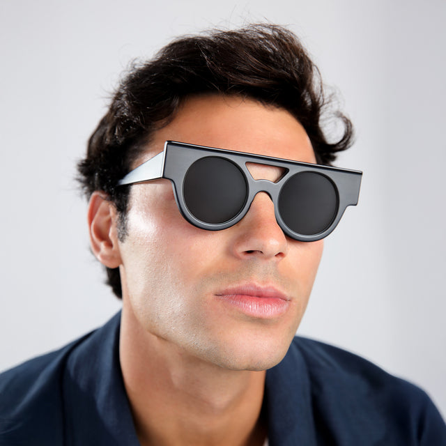 Another angle of man in a navy shirt wearing Meyer (15 Year Anniversary) Sunglasses Matte Black with Grey Flat