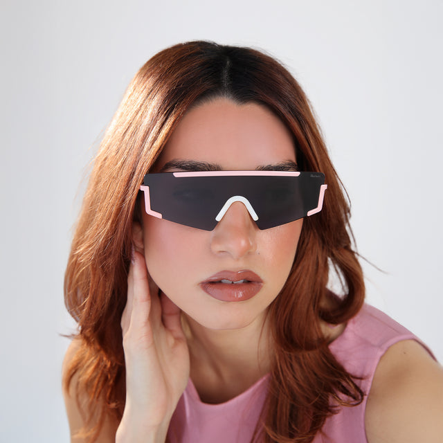 Woman with red hair in a bubblegum pink blouse wearing Morph Sunglasses Baby Pink/Cream Marble with Grey