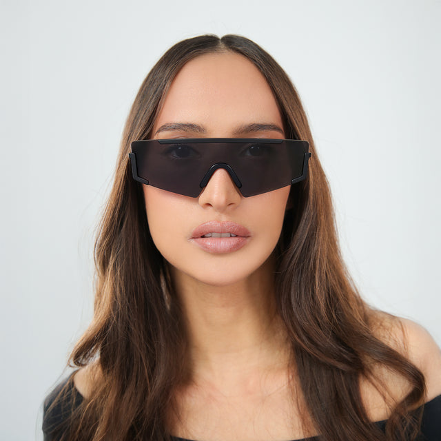Another angle of woman with brown hair in an off-the-shoulder blouse wearing Morph Sunglasses Matte Black with Grey