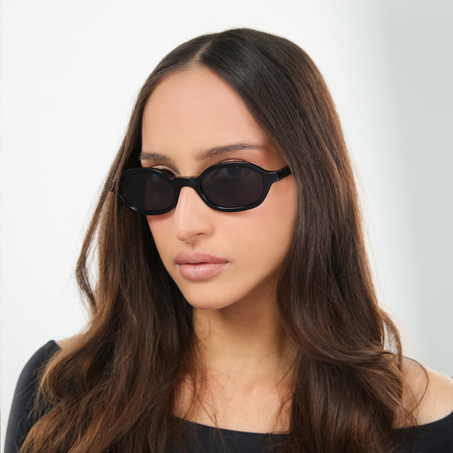 Another angle of brunette woman in an off-the-shoulder blouse wearing Munich Sunglasses Black with Grey Flat