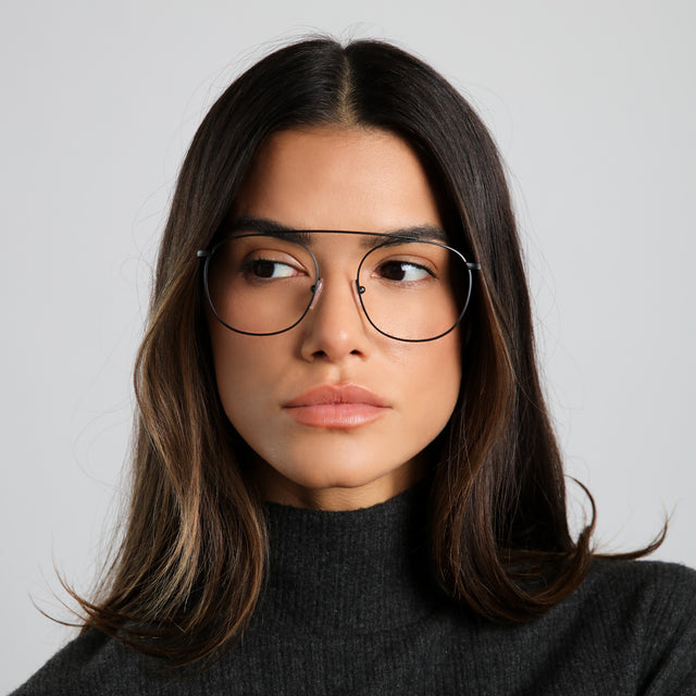 Brunette woman in a black cashmere turtleneck wearing Mykonos Optical Matte Black Optical