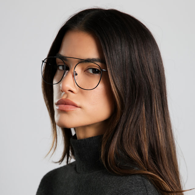 Another angle of brunette woman in a black cashmere turtleneck wearing Mykonos Optical Matte Black Optical