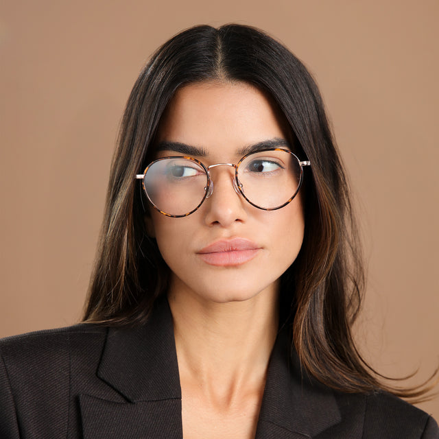 Brunette woman wearing a black blazer wearing Oxford Optical Tortoise/Rose Gold Optical
