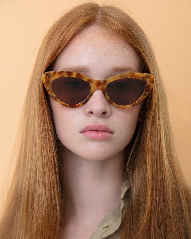 Model with straight, red hair wearing Pamela Sunglasses Amber with Brown Flat