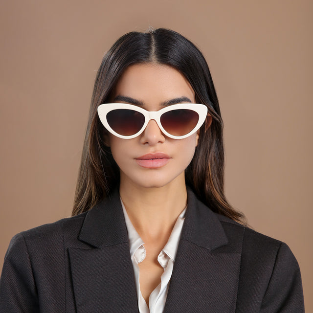 Brunette model in a black wool blazer wearing Pamela Sunglasses Cream with Brown Flat Gradient