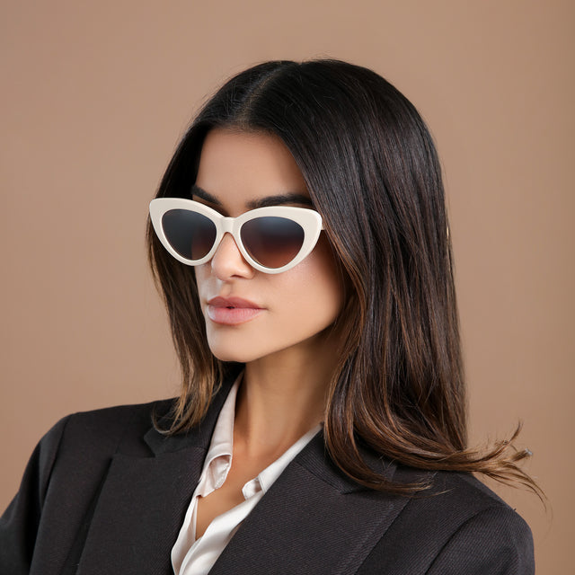 Brunette model in a black wool blazer looking left wearing Pamela Sunglasses Cream with Brown Flat Gradient
