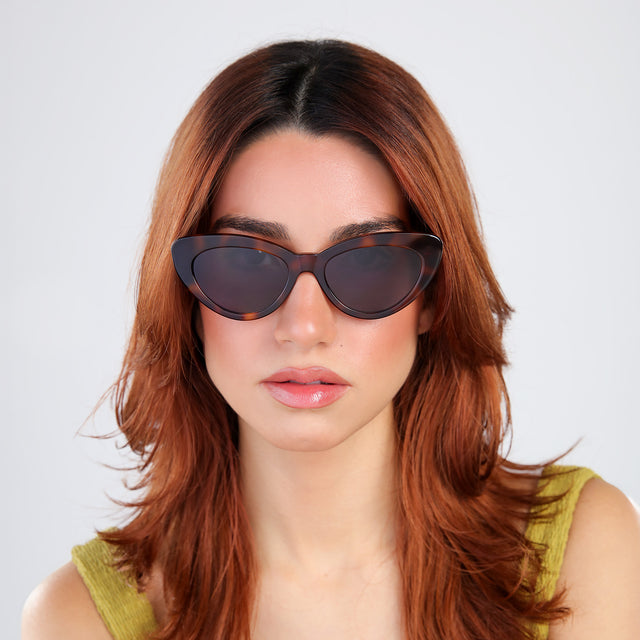Woman with red hair in a chartrieusse blouse wearing Pamela Sunglasses Havana with Grey Flat