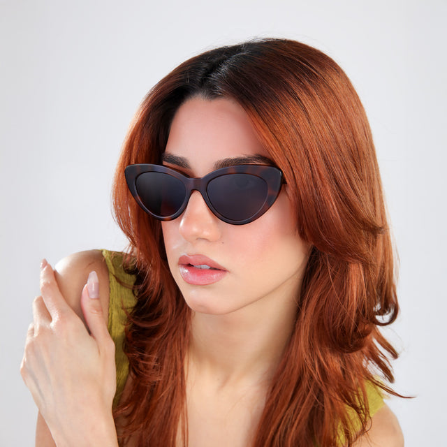 Woman with red hair in a chartrieusse blouse looking right wearing Pamela Sunglasses Havana with Grey Flat