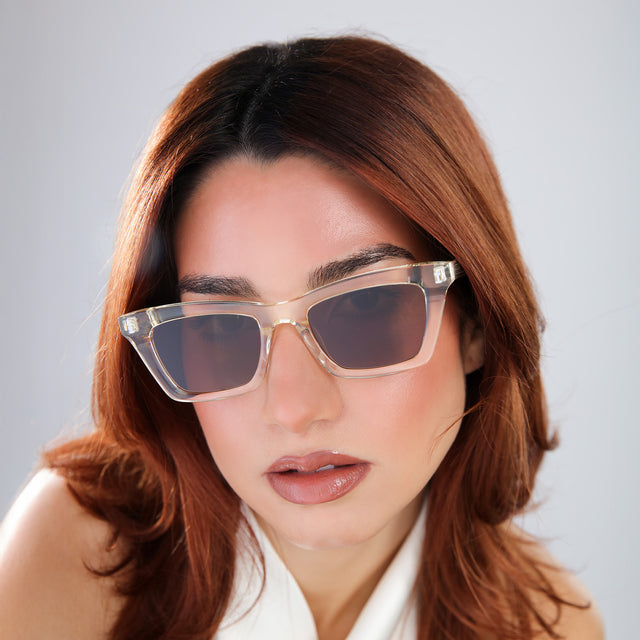 Woman with red hair in a white blouse wearing Portugal Sunglasses Champagne with Brown Flat