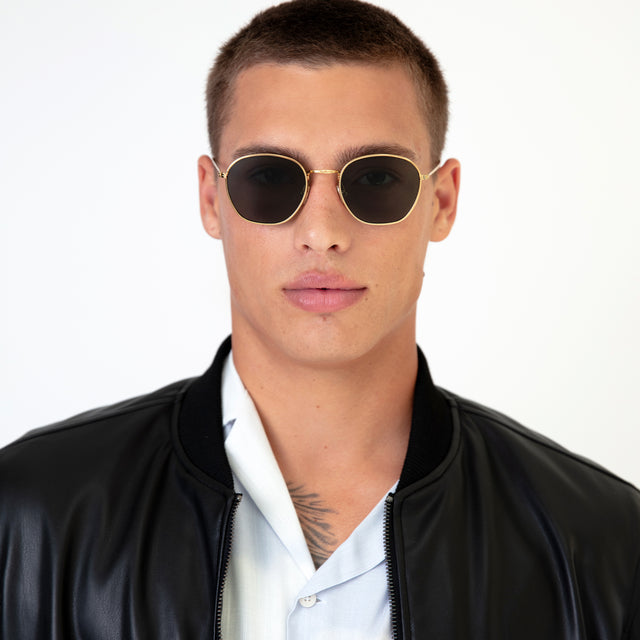Model with buzzcut hairstyle wearing Prince Sunglasses Gold with Olive Flat