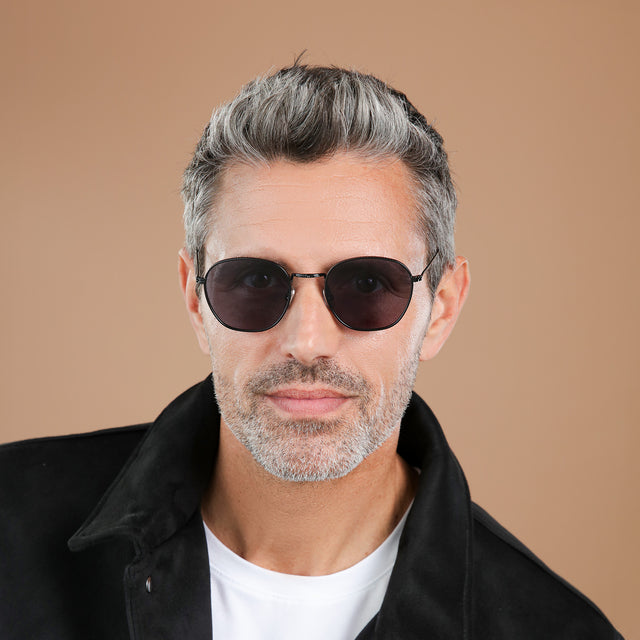 Man with salt and pepper hair and beard wearing Prince Sunglasses Black with Grey Flat
